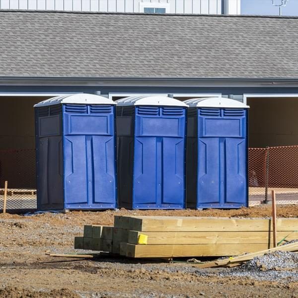 Two portable toilets staged on an active Weston, FL construction site