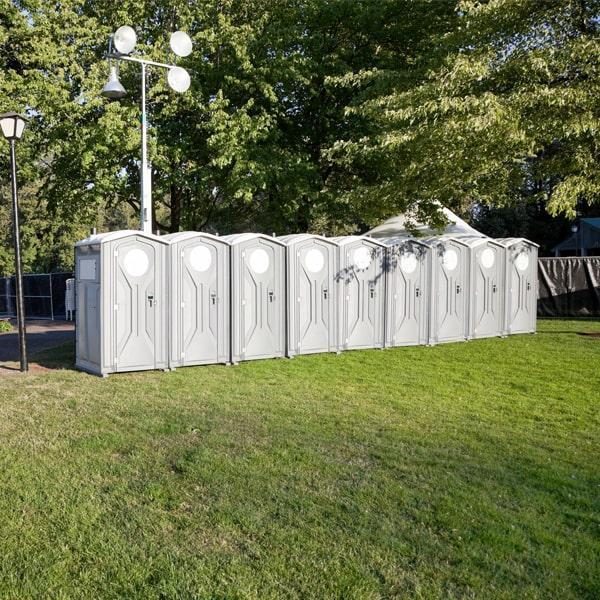 Row of deluxe portable restrooms staged outdoors for an event