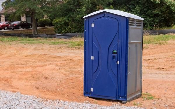 Two portable restrooms set up on the lawn for an outdoor event
