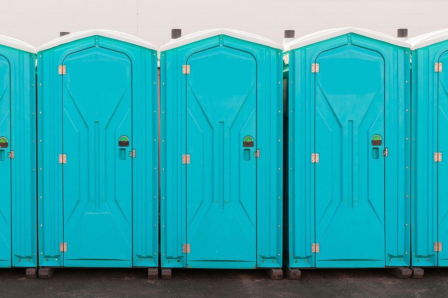 Close-up of clean teal portable restroom units side by side