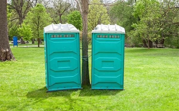 Two portable toilets placed long-term on a grass property in Weston, FL